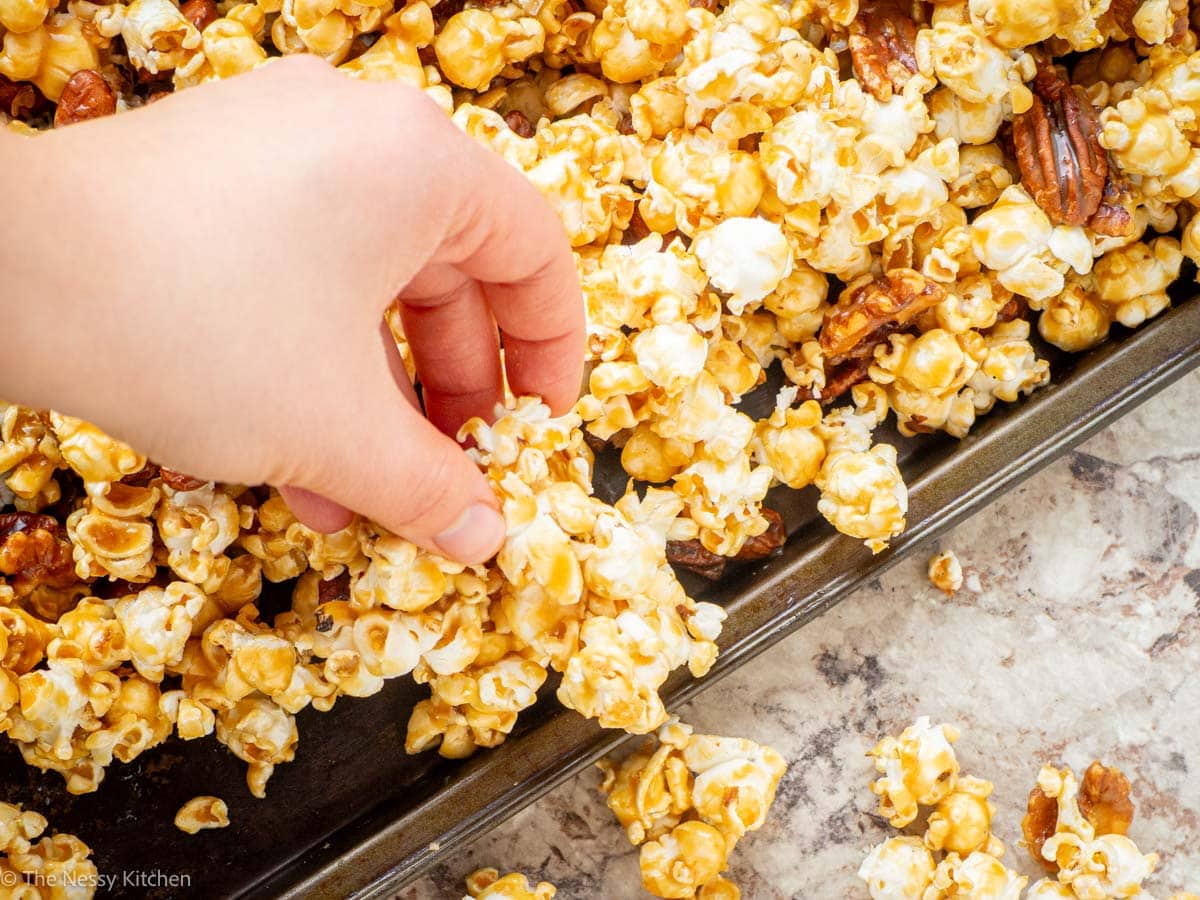 Hand breaking poppycock into pieces for serving.