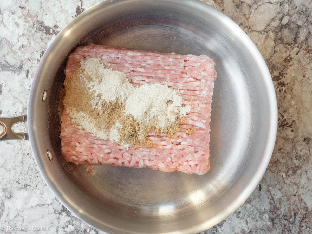 Ground pork in a skillet with spices.