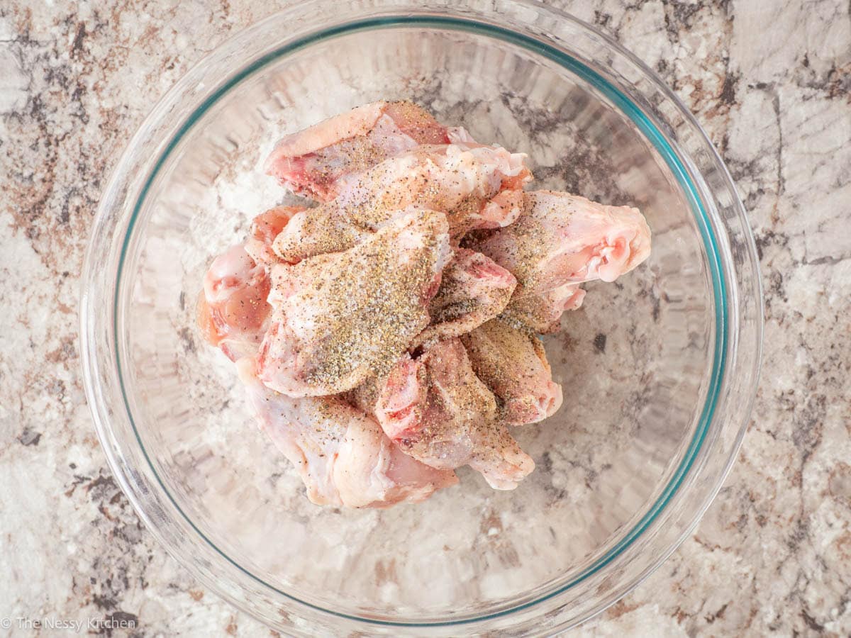 Chicken wings in a bowl with spices.