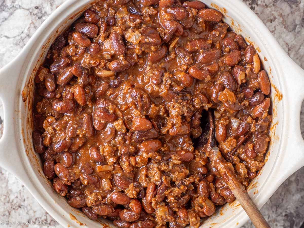 Beans and beef stirred together in a baking dish.