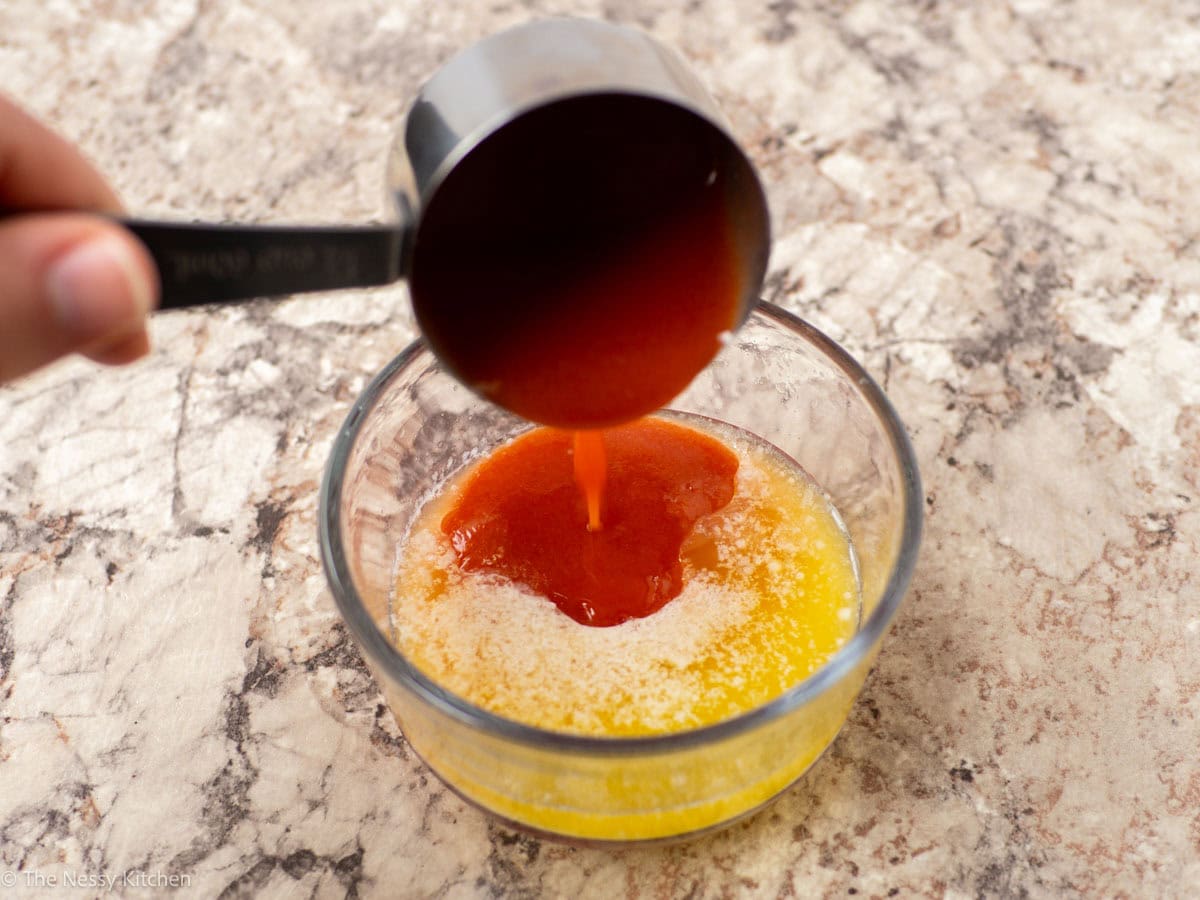 Butter and hot sauce mixed together in a bowl.