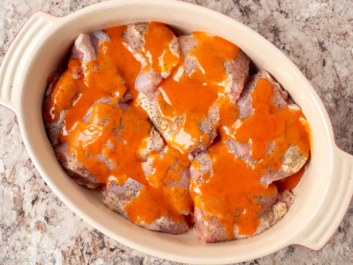 Chicken thighs covered in Buffalo sauce.