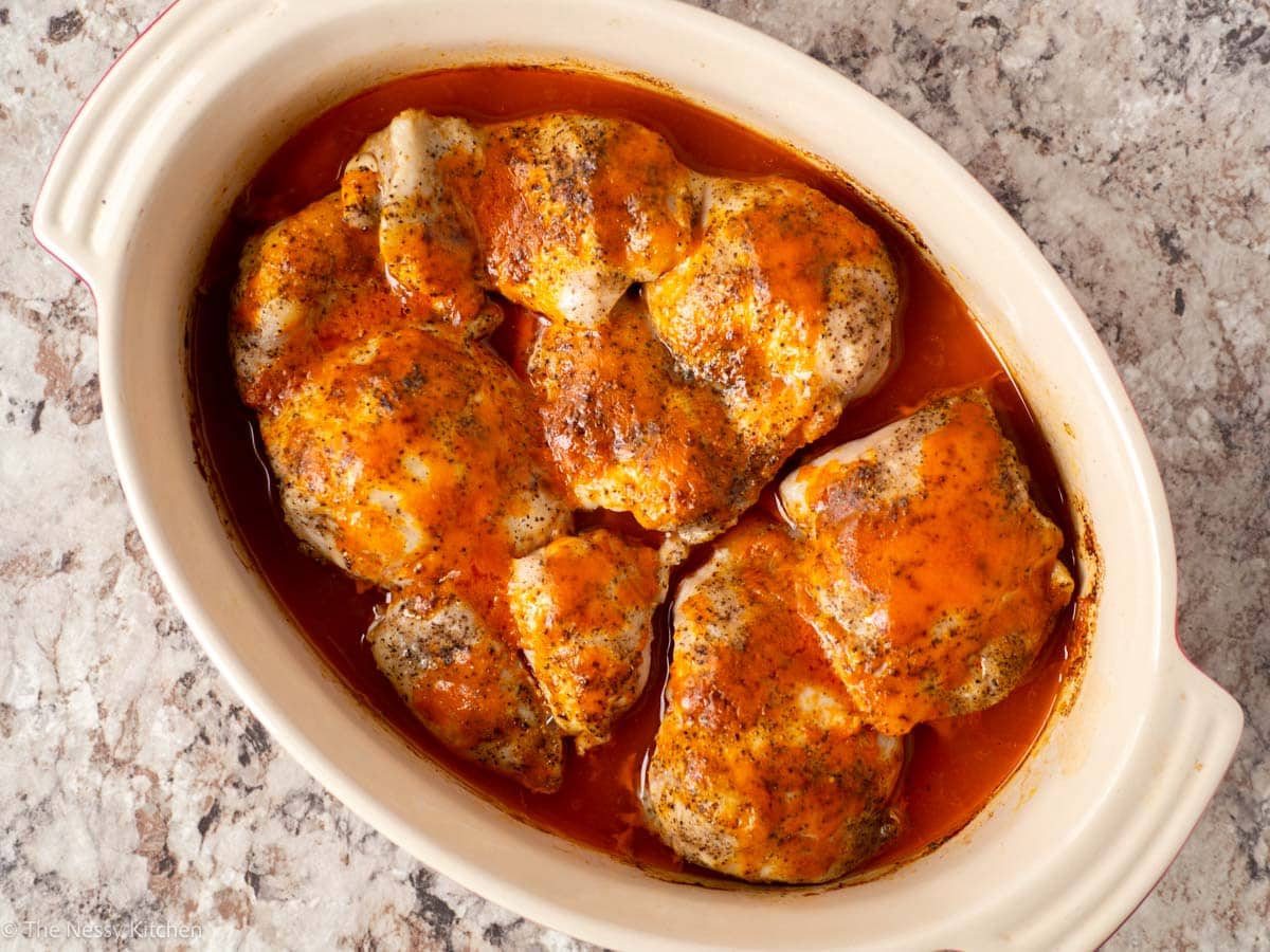 Baked chicken thighs in a casserole dish.