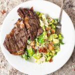 Salad on a plate with steak.
